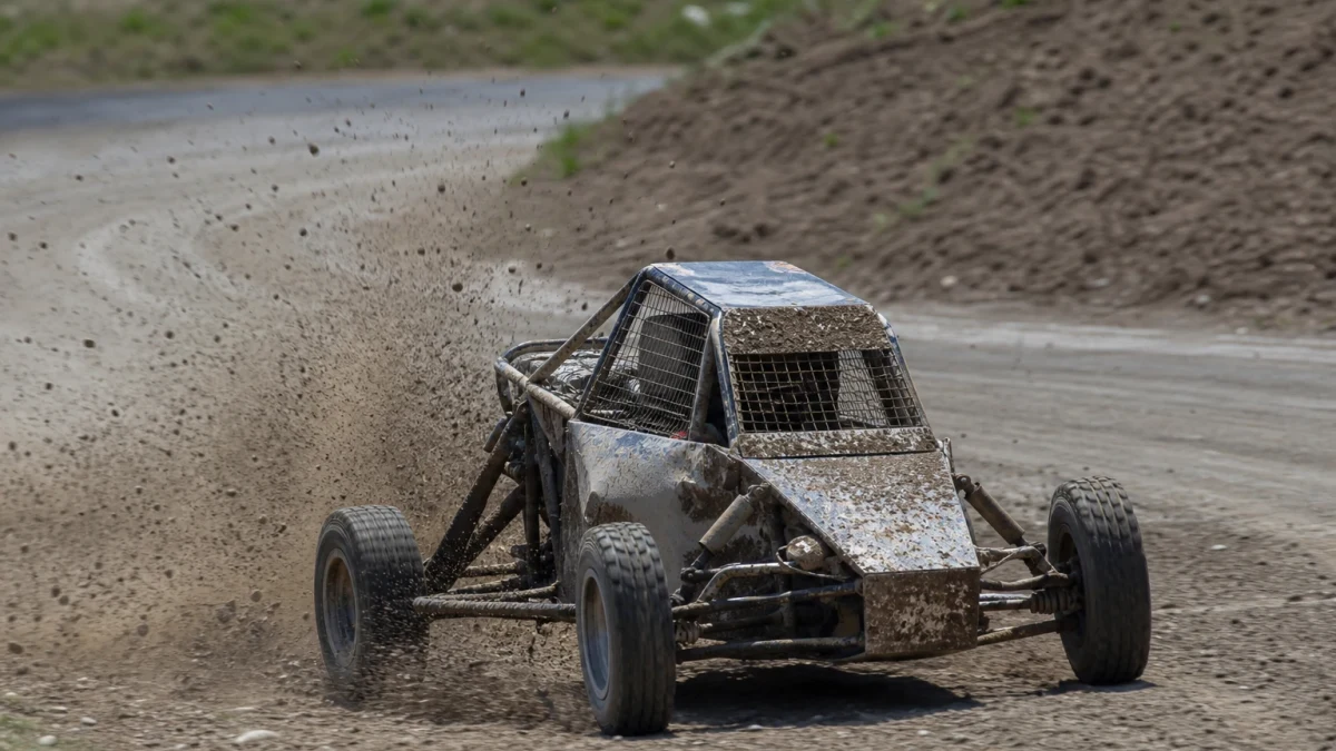 Crosskart-bil som sladdar genom en gruskurva