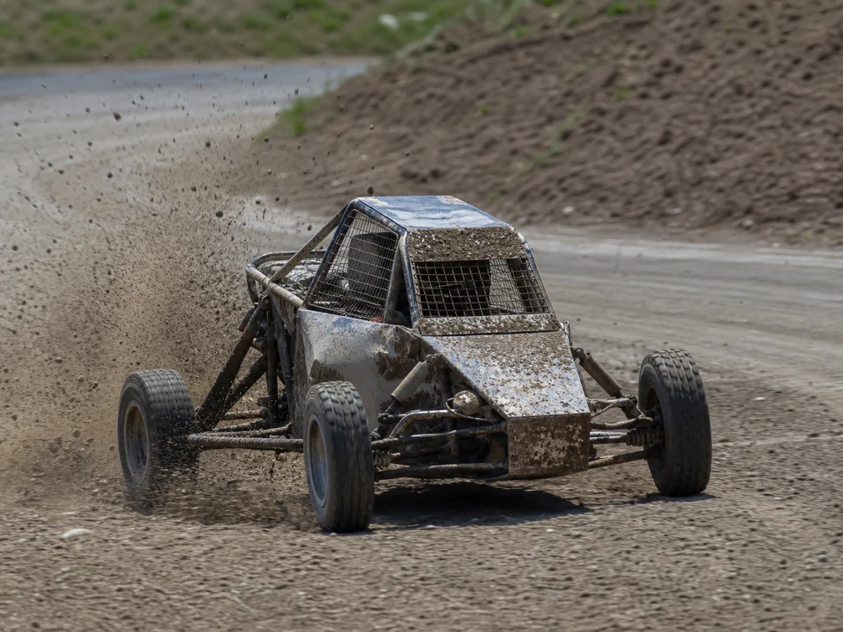 Crosskart-bil som sladdar genom en gruskurva