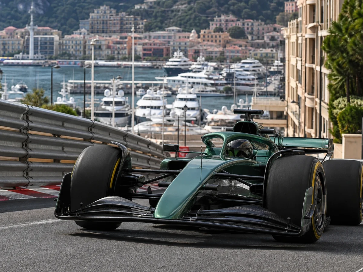 F1-bil på Monacos gata med hamnen och husfasader i bakgrunden