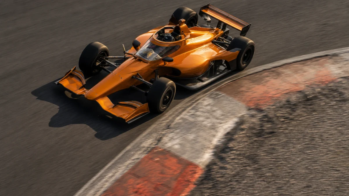 IndyCar-bil i full fart på en oval med öppna hjul och aeroskärm