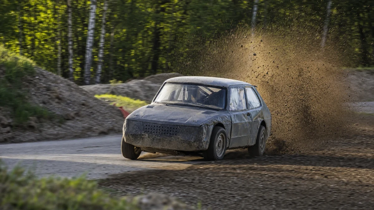 Rallycrossbil i grusrök som illustrerar teamet JC Raceteknik