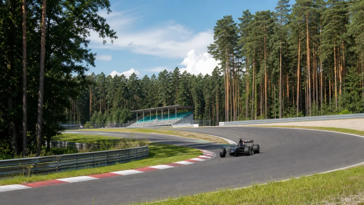 Racerbilar i en tät kurva på en svensk permanent racerbana.